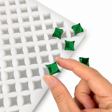 Hand drukt een smaragdgroene gummy in de 2 mL stervorm met 192 holtes